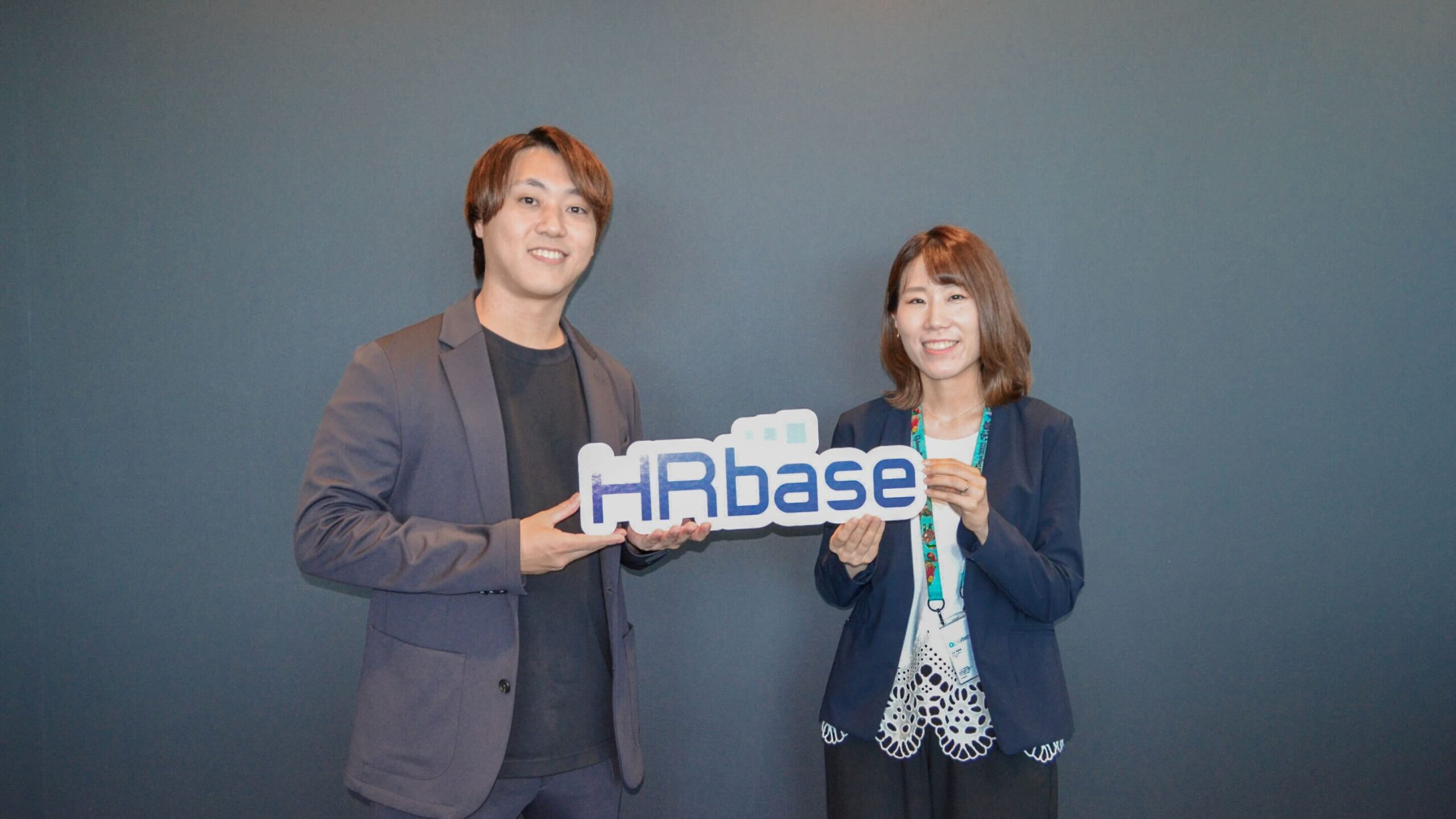 HRbaseロゴを持つ大内さんと米谷さん